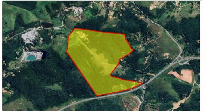 Imagem de satélite com a poligonal da gleba destacada em amarelo e contorno vermelho, com a mineração a oeste e a estrada vicinal ao sul